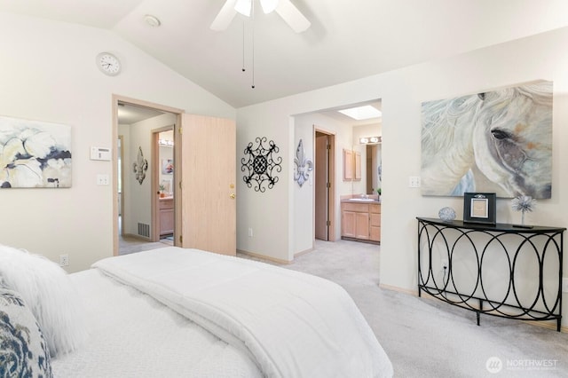bedroom featuring light colored carpet, lofted ceiling, connected bathroom, baseboards, and a ceiling fan