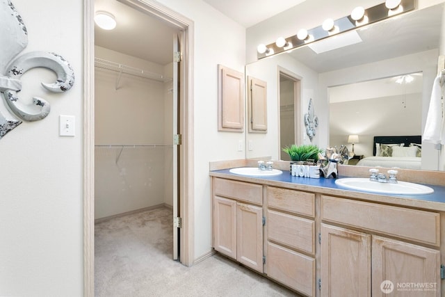 ensuite bathroom with double vanity and a walk in closet