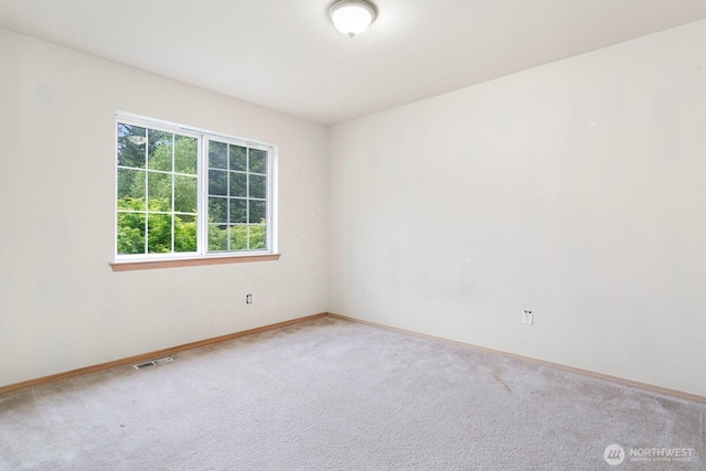 unfurnished room featuring carpet and baseboards