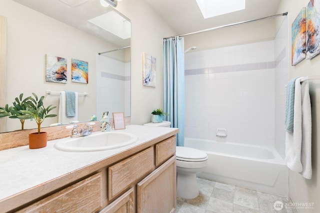 bathroom featuring a skylight, toilet, vanity, and shower / tub combo