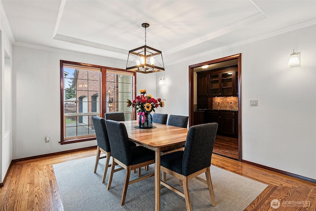 16915 32nd Ave E, Tacoma, WA 98446 - dining space with a chandelier, a raised ceiling, light wood-style floors, baseboards, and ornamental molding