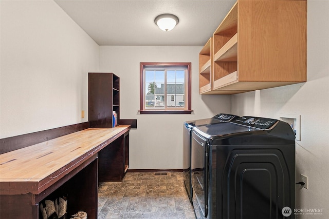 16915 32nd Ave E, Tacoma, WA 98446 - clothes washing area featuring cabinet space, washer and clothes dryer, baseboards, and stone finish flooring