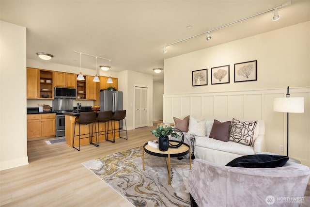 120 Hall Brothers Loop NW Unit 103, Bainbridge Island, WA 98110 - living area with rail lighting, light wood-style floors, and wainscoting