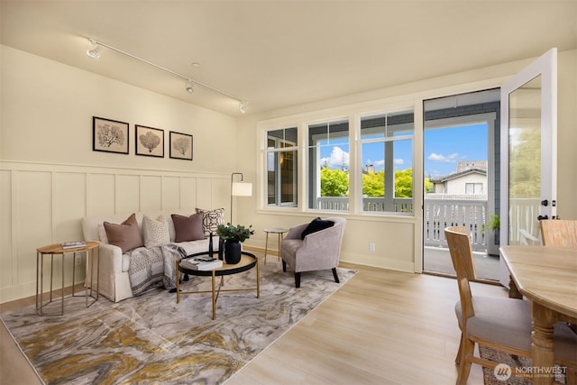 120 Hall Brothers Loop NW Unit 103, Bainbridge Island, WA 98110 - living room featuring track lighting, wood finished floors, a decorative wall, and a wainscoted wall