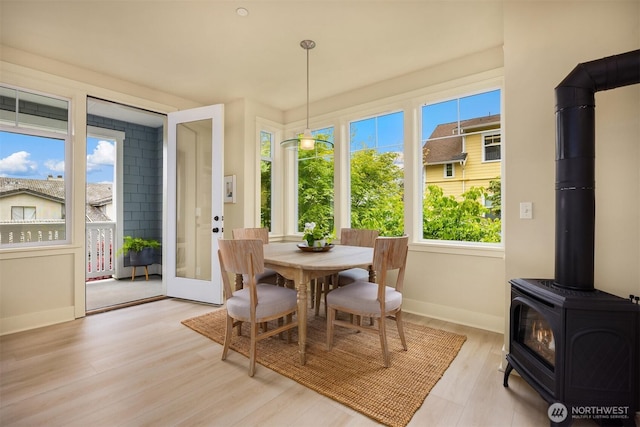 120 Hall Brothers Loop NW Unit 103, Bainbridge Island, WA 98110 - dining space featuring a wood stove, light wood-style floors, and baseboards