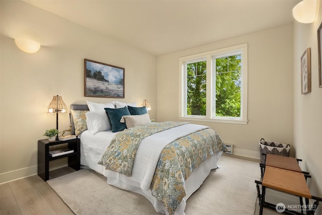 120 Hall Brothers Loop NW Unit 103, Bainbridge Island, WA 98110 - bedroom with baseboards, wood finished floors, and a baseboard radiator
