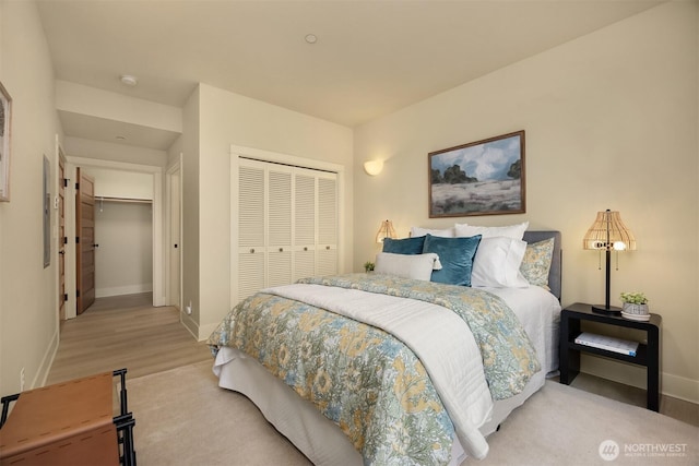 120 Hall Brothers Loop NW Unit 103, Bainbridge Island, WA 98110 - bedroom with a closet, baseboards, and light wood-style flooring