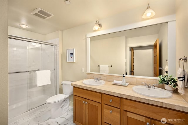 120 Hall Brothers Loop NW Unit 103, Bainbridge Island, WA 98110 - full bathroom featuring marble finish flooring, toilet, a shower stall, and double vanity