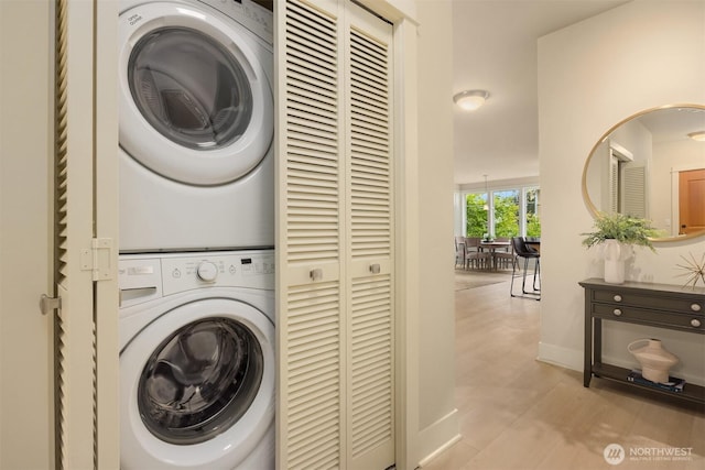 120 Hall Brothers Loop NW Unit 103, Bainbridge Island, WA 98110 - laundry area featuring stacked washer and clothes dryer, baseboards, and wood finished floors
