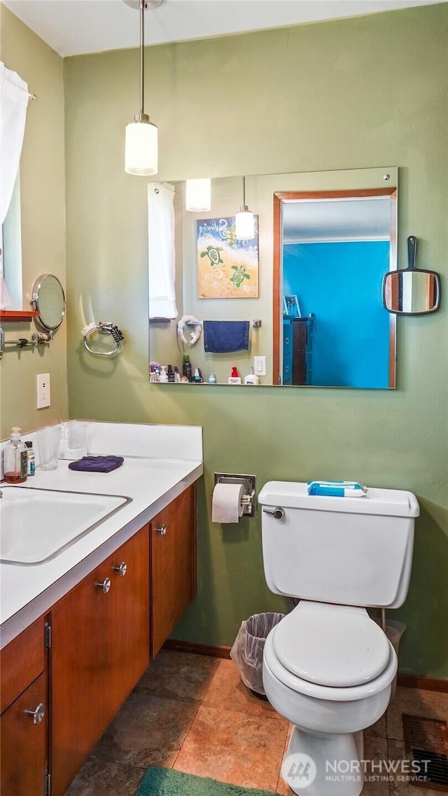 1102 E Elm St, Othello, WA 99344 - bathroom featuring vanity, toilet, and baseboards