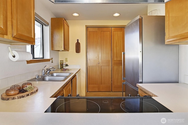 1604 11th Ave S Unit 402, Seattle, WA 98134 - kitchen with freestanding refrigerator, a sink, brown cabinetry, light countertops, and recessed lighting