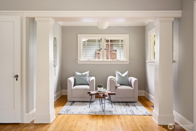 sitting room featuring wood finished floors, ornamental molding, and baseboards