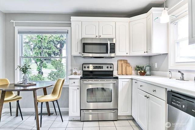 4124 SW 104th St, Seattle, WA 98146 - kitchen featuring appliances with stainless steel finishes, a sink, white cabinetry, and light countertops