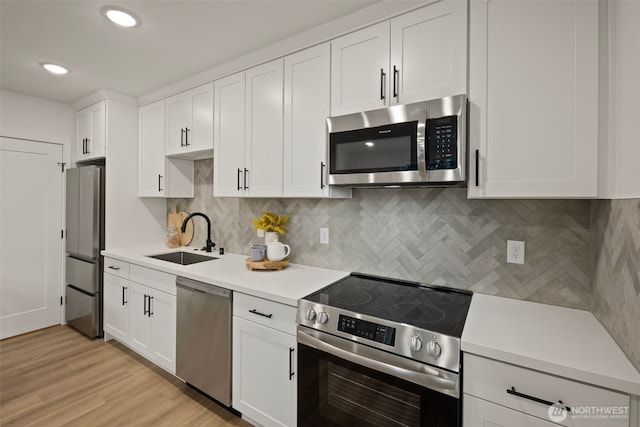 1050C S Donovan St, Seattle, WA 98108 - kitchen featuring stainless steel appliances, a sink, light countertops, white cabinetry, and decorative backsplash