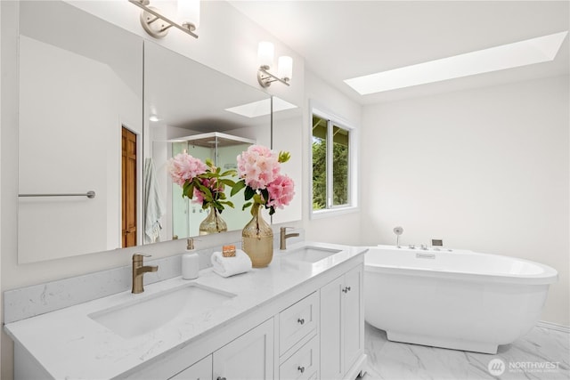 8484 NE County Park Rd, Bainbridge Island, WA 98110 - bathroom with marble look tile flooring, double vanity, a freestanding bath, and a skylight