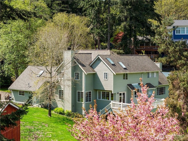 8484 NE County Park Rd, Bainbridge Island, WA 98110 - rear view of house with a chimney, a lawn, and a shingled roof