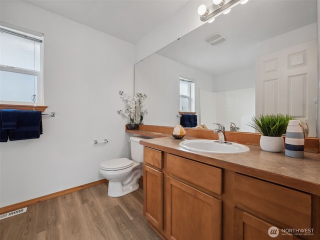 bathroom featuring wood finished floors, toilet, and vanity