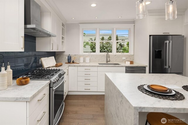 421 16th Ave E, Seattle, WA 98112 - kitchen with appliances with stainless steel finishes, wall chimney range hood, a sink, dark wood-style flooring, and white cabinetry