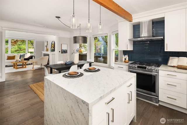 421 16th Ave E, Seattle, WA 98112 - kitchen with wall chimney range hood, stainless steel gas stove, backsplash, light stone counters, and beam ceiling