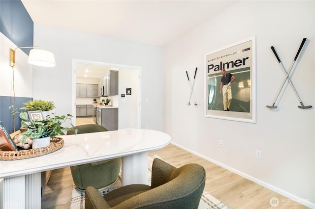 dining area featuring light wood-type flooring and baseboards
