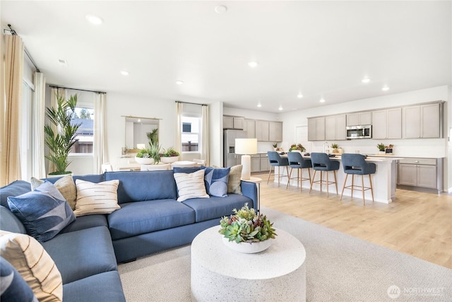 living area with recessed lighting and light wood-style floors