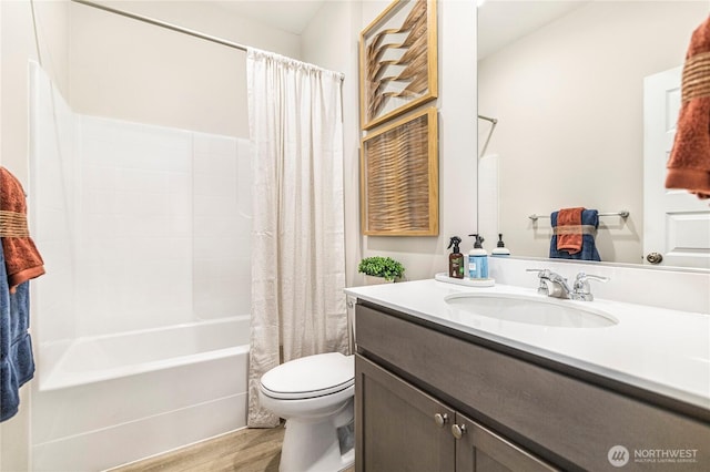 full bath with toilet, vanity, wood finished floors, and shower / bath combo