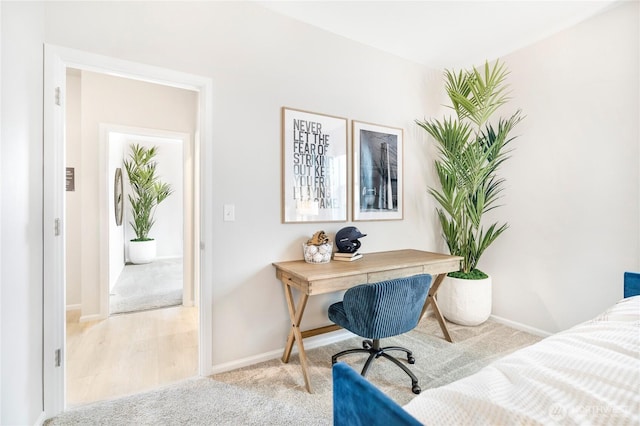 carpeted bedroom with baseboards and an office area