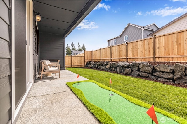 view of yard featuring an area to practice putting and a patio