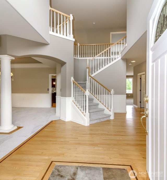 3612 Spyglass Dr NE, Tacoma, WA 98422 - entrance foyer with wood finished floors, stairway, a towering ceiling, arched walkways, and wainscoting