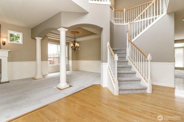 3612 Spyglass Dr NE, Tacoma, WA 98422 - entryway with decorative columns, a wainscoted wall, arched walkways, wood finished floors, and stairs