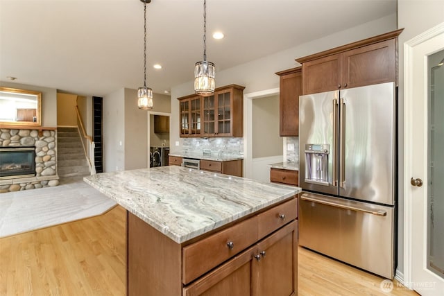 3612 Spyglass Dr NE, Tacoma, WA 98422 - kitchen with high end fridge, separate washer and dryer, light wood-style flooring, light stone counters, and recessed lighting