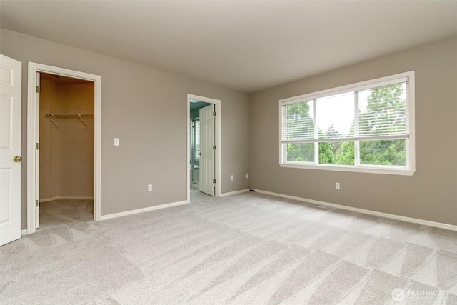 3612 Spyglass Dr NE, Tacoma, WA 98422 - unfurnished bedroom with a spacious closet, light carpet, baseboards, and connected bathroom
