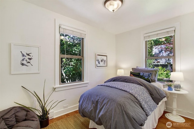 7508 13th Ave SW, Seattle, WA 98106 - bedroom featuring multiple windows, baseboards, and wood finished floors