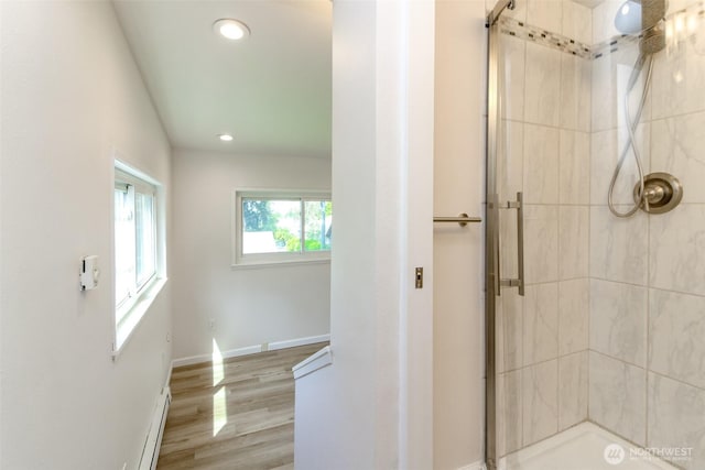 full bathroom with a shower with shower door, wood finished floors, recessed lighting, baseboards, and baseboard heating