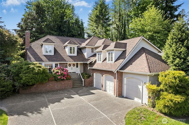 4877 167th Ave SE, Bellevue, WA 98006 - view of front facade featuring concrete driveway, a chimney, brick siding, roof with shingles, and a garage
