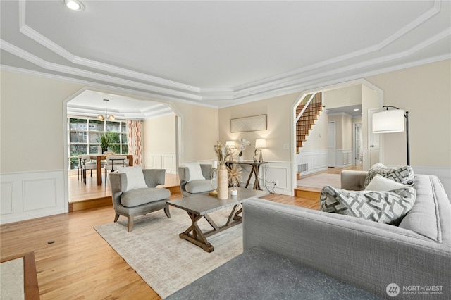 4877 167th Ave SE, Bellevue, WA 98006 - living area featuring a tray ceiling, ornamental molding, a chandelier, light wood-style floors, and arched walkways