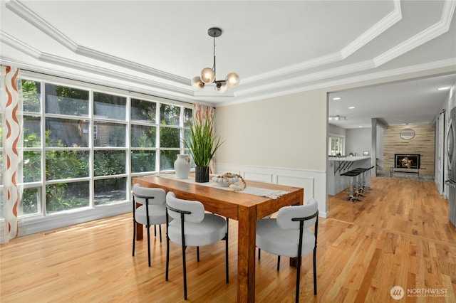 4877 167th Ave SE, Bellevue, WA 98006 - dining space featuring a tray ceiling, plenty of natural light, crown molding, light wood finished floors, and a wainscoted wall