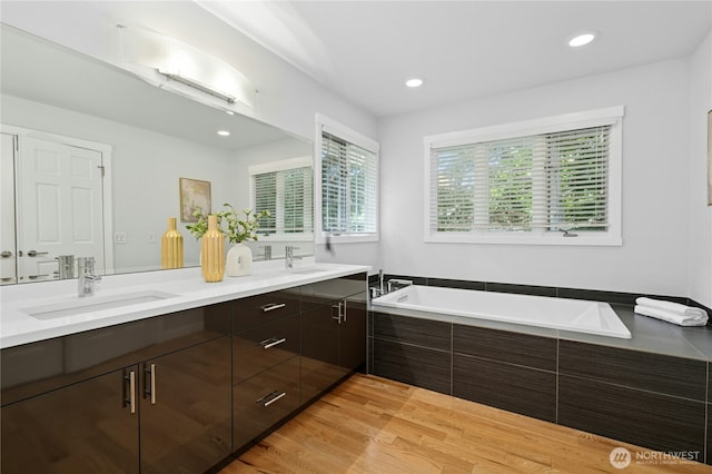 4877 167th Ave SE, Bellevue, WA 98006 - bathroom with double vanity, a garden tub, wood finished floors, and recessed lighting