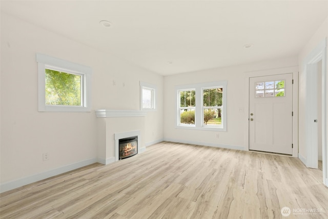 320 Kearney St, Centralia, WA 98531 - unfurnished living room featuring a lit fireplace, light wood-type flooring, and baseboards