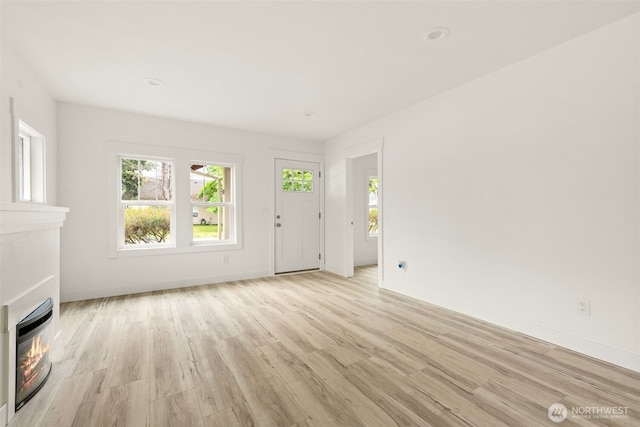 320 Kearney St, Centralia, WA 98531 - unfurnished living room featuring a glass covered fireplace, light wood finished floors, and plenty of natural light