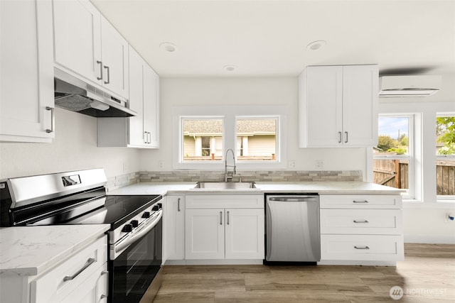 320 Kearney St, Centralia, WA 98531 - kitchen featuring appliances with stainless steel finishes, a sink, under cabinet range hood, white cabinetry, and recessed lighting