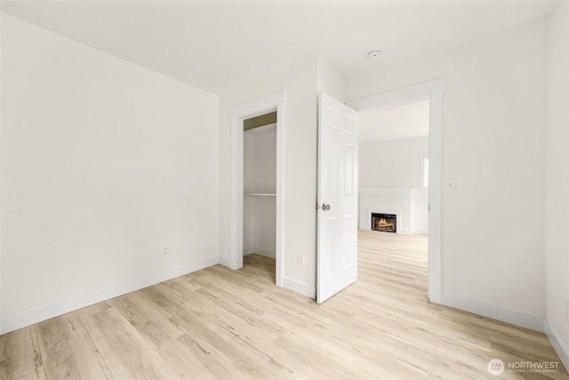 320 Kearney St, Centralia, WA 98531 - unfurnished bedroom with a warm lit fireplace, light wood-style floors, baseboards, and a closet