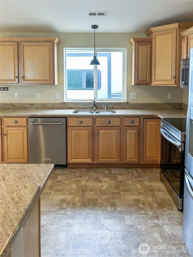 510 Oregon Ave N, Long Beach, WA 98631 - kitchen with appliances with stainless steel finishes, a sink, stone finish flooring, hanging light fixtures, and light brown cabinetry