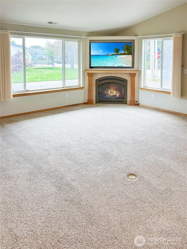 510 Oregon Ave N, Long Beach, WA 98631 - unfurnished living room with a tiled fireplace, carpet floors, baseboards, and vaulted ceiling