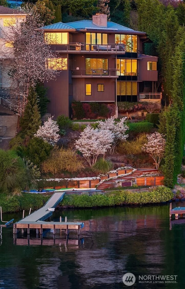 7703 W Mercer Way, Mercer Island, WA 98040 - back of property featuring a water view, a chimney, and metal roof
