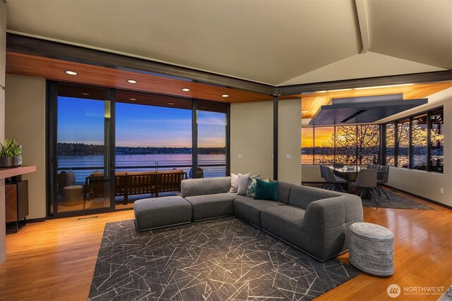 7703 W Mercer Way, Mercer Island, WA 98040 - living area with lofted ceiling, a water view, and wood finished floors