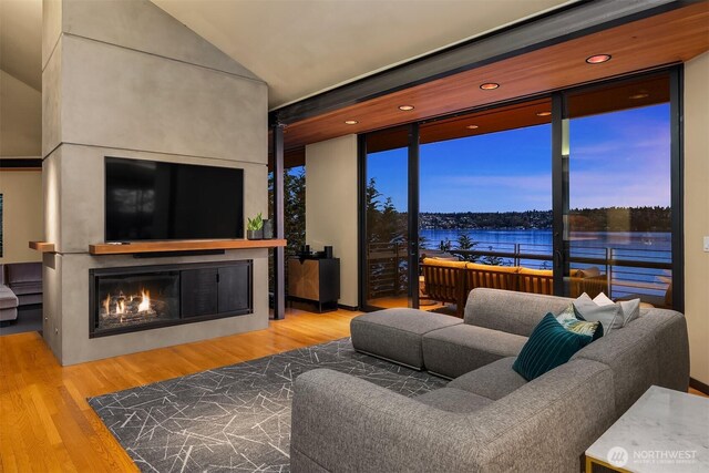 7703 W Mercer Way, Mercer Island, WA 98040 - living area featuring a lit fireplace, wood finished floors, and floor to ceiling windows