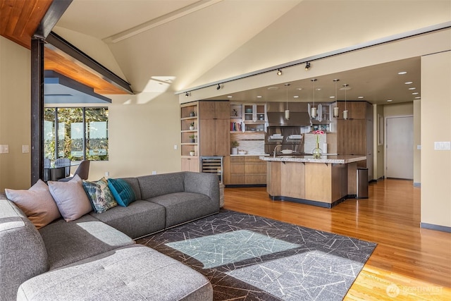 7703 W Mercer Way, Mercer Island, WA 98040 - living room with light wood-type flooring, wine cooler, recessed lighting, and lofted ceiling