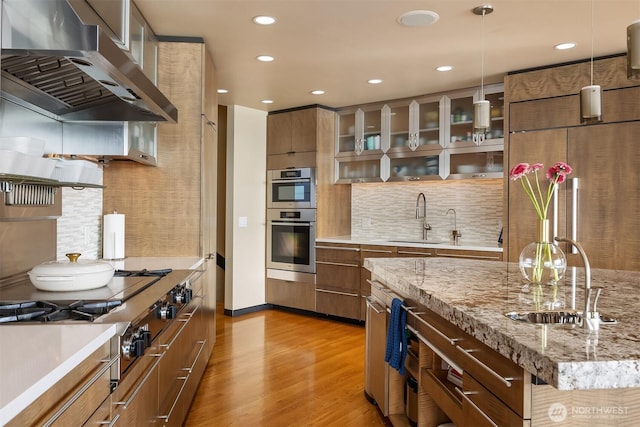 7703 W Mercer Way, Mercer Island, WA 98040 - kitchen featuring a sink, extractor fan, light wood finished floors, tasteful backsplash, and recessed lighting