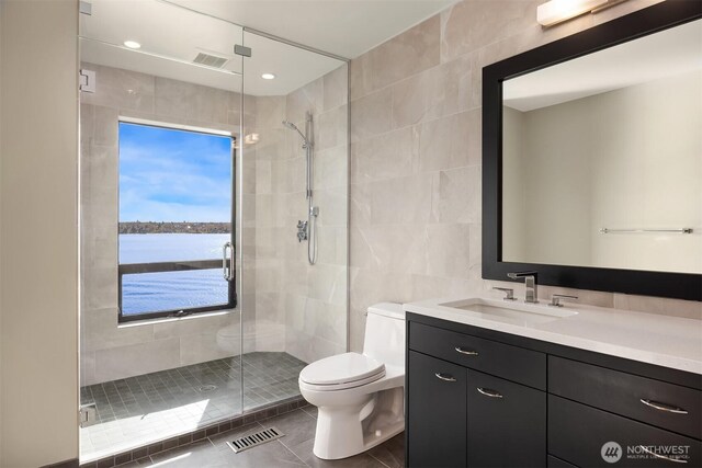 7703 W Mercer Way, Mercer Island, WA 98040 - bathroom with tile walls, toilet, vanity, a shower stall, and tile patterned flooring